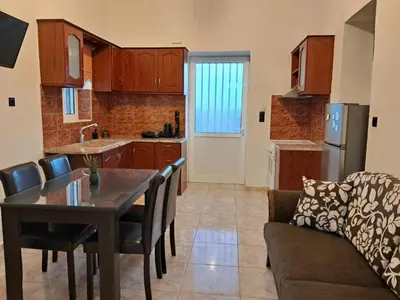 a kitchen and living room with a table and a couch at La casa de Ioanna in Kissamos