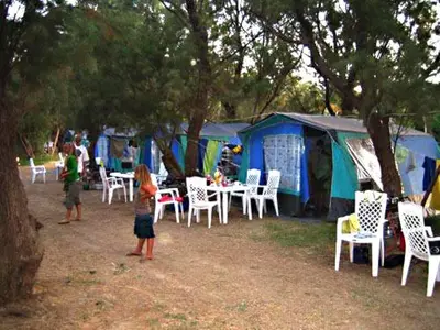 two children standing in front of a group of chairs and tents at Camping Mithimna in Kissamos