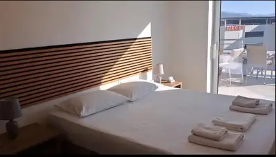 a bedroom with a large white bed with two towels on it at Penthouse Apartment in Chania Heart in Chania Town