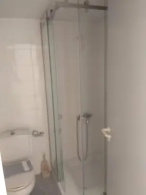 a bathroom with a glass shower with a toilet at Kyriaki Hotel in Kato Daratso