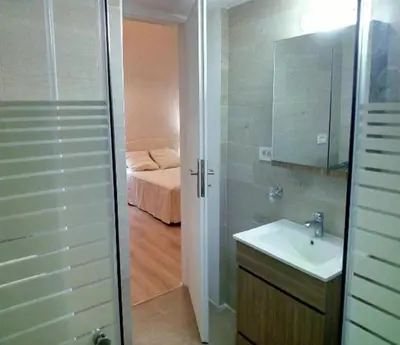 a bathroom with a shower and a sink and a bed at Kissamos Grandfather's House in Kissamos