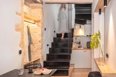 a room with a staircase and a kitchen with a table at Eva Plus in Chania Town