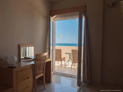 a room with a desk and a view of the ocean at Alexandra SeaSide Villas in Plataniás