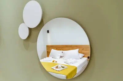 a room with a bed with a round mirror at Iliovasilema Apartments in Elafonisi