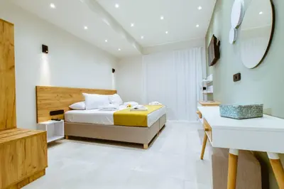 a white bedroom with a bed and a sink at Iliovasilema Apartments in Elafonisi