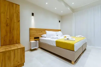 a bedroom with a large bed with a yellow blanket at Iliovasilema Apartments in Elafonisi