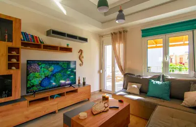 a living room with a large flat screen tv at Bitsakis Family - Paleochora Luxury Villa in Palaiochóra