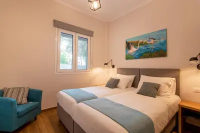 a bedroom with a bed and a blue chair at Bitsakis Family - Paleochora Luxury Villa in Palaiochóra