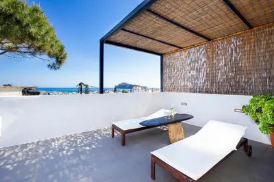 a patio with a table and chairs and a wall at Cretan Loft in Plataniás