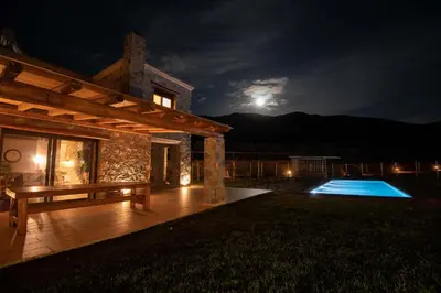 a house with a bench and a swimming pool at night at Villa Kore Elafonissi in Ãyios FÃ³tios