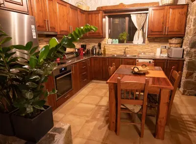 a kitchen with wooden cabinets and a wooden table at Villa Kore Elafonissi in Ãyios FÃ³tios
