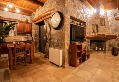 a kitchen with a clock on a stone wall at Villa Kore Elafonissi in Ãyios FÃ³tios