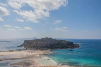 an island in the ocean with a boat in the water at History and Charm in Chania Town