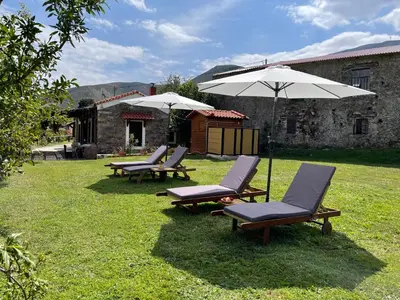 a group of chairs and umbrellas in a yard at Authentic Cottage in a heaven of natural Beauty in Chania Town