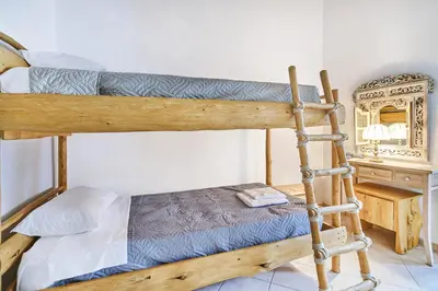 a bedroom with two bunk beds and a mirror at Authentic Cottage in a heaven of natural Beauty in Chania Town