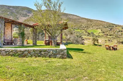 a house in a field with a stone wall at Authentic Cottage in a heaven of natural Beauty in Chania Town