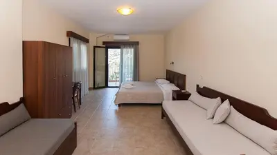 a hotel room with two beds and a couch at Anopoli Rooms in Anopoli Sfakion