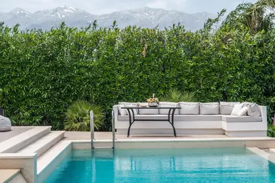 a white couch sitting next to a pool at Miraida Exclusive Residence in Almirida