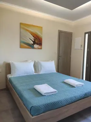 a bedroom with a bed with two towels on it at Wish Sea & Mountain View in Stalos