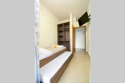 a small room with two beds and a mirror at Mantarini House in Áyios Andónios