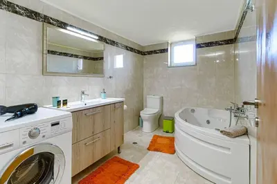 a bathroom with a sink and a washing machine in it at Mantarini House in Áyios Andónios