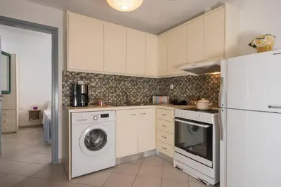 a kitchen with a washer and a white refrigerator at Peraspitaki in Chania Town