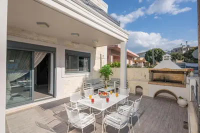 a patio with a table and chairs and a fireplace at Villa Antoni in Galatás
