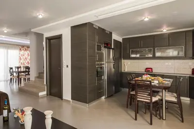 a kitchen and dining room with a table and chairs at Villa Antoni in Galatás
