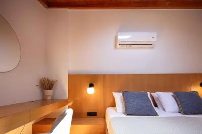 a bedroom with a bed with two blue pillows on it at Omnia Villas - 