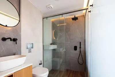 a bathroom with a shower with a toilet and a sink at Omnia Villas - 