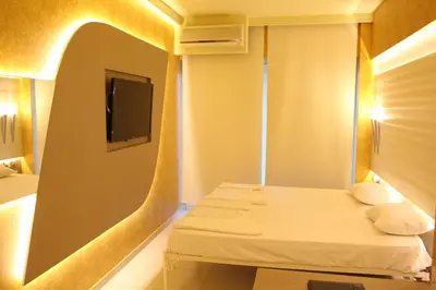 a hotel room with two beds and a tv at Oneiro Suites in Souda