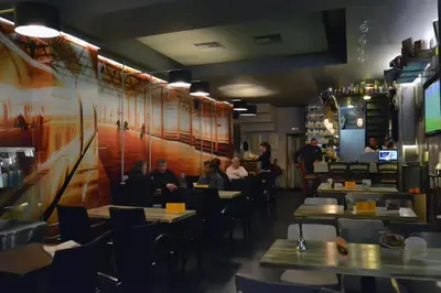 a restaurant with people sitting at tables in a restaurant at Oneiro Suites in Souda