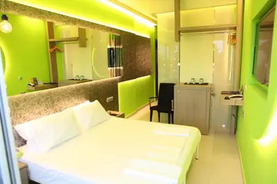 a bedroom with a white bed and a green wall at Oneiro Suites in Souda