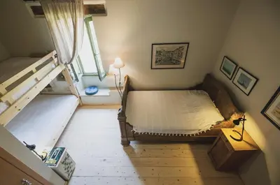 an attic bedroom with two beds and a staircase at Casa Olea - A Venetian era Home with Courtyard in Kondomari
