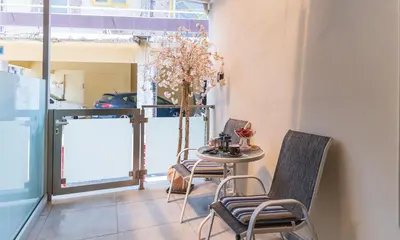 a table and chairs in a room with a window at Apolafsi Apartments 2 New with kitchen in Chania Town