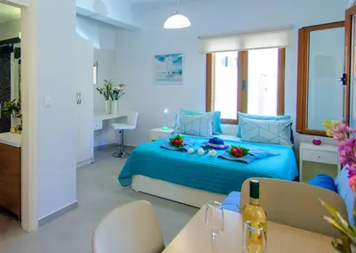 a bedroom with a blue bed with flowers on it at Apolafsi Apartments 1New with kitchen in Chania Town