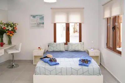 a bedroom with a bed with blue sheets and blue pillows at Apolafsi Apartments 1New with kitchen in Chania Town