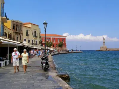 a group of people walking on a sidewalk next to the water at Apolafsi Apartments 1New with kitchen in Chania Town