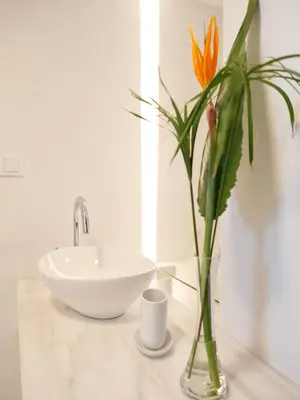 a bathroom with a sink and a vase with a flower at Chania Locals Flat in Chania Town