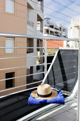 a straw hat sitting on a towel on a balcony at Chania Locals Flat in Chania Town