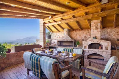 a patio with a table and a stone fireplace at Traditional Crete Villa Villa Green Faskomilia Stunning Views 1 Bedroom in Khiliomoudhoú