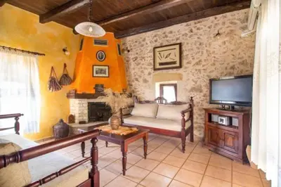 a living room with a couch and a tv at Traditional Crete Villa Villa Orange Diktamos Stunning Views 1 Bedroom in Khiliomoudhoú