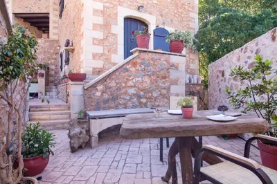 an outdoor patio with a wooden table and a building at Samonas Traditional Villas Purple Villa Malotira - 85M² Maisonette in Khiliomoudhoú