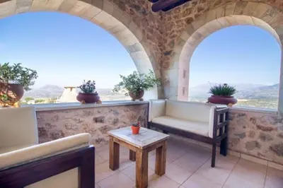a balcony with two chairs and a table and two windows at Samonas Traditional Villas Purple Villa Malotira - 85M² Maisonette in Khiliomoudhoú