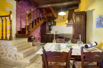 a kitchen with a table with chairs and a staircase at Samonas Traditional Villas Purple Villa Malotira - 85M² Maisonette in Khiliomoudhoú