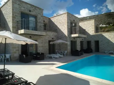 a villa with a swimming pool in front of a building at Villa Stylianos retreat in Kissamos