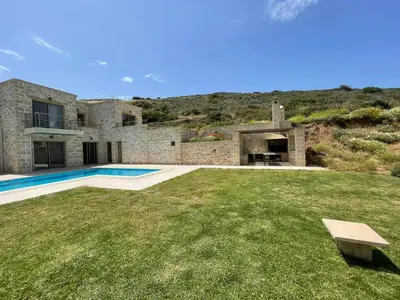 a stone house with a swimming pool in a yard at Villa Stylianos retreat in Kissamos