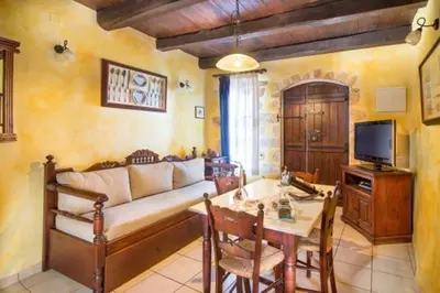 a living room with a couch and a table at Traditional Crete Villa Villa Blue Mantzourana Stunning Views 1 Bedroom in Khiliomoudhoú
