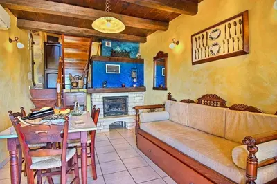 a living room with a couch and a table and a fireplace at Traditional Crete Villa Villa Blue Mantzourana Stunning Views 1 Bedroom in Khiliomoudhoú
