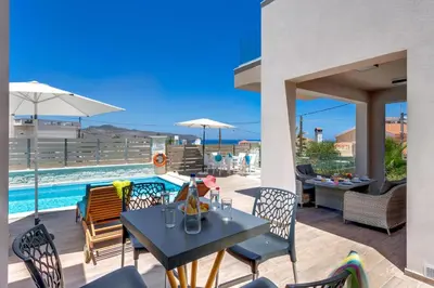 a patio with a table and chairs and a pool at Luxury Villa Crete Villa Marina Mare 3 Bedroom Private Pool in Chania Town